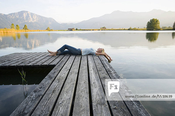 A woman lying down on the pier.