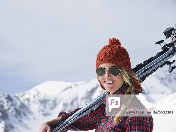 Woman holding skis on shoulder