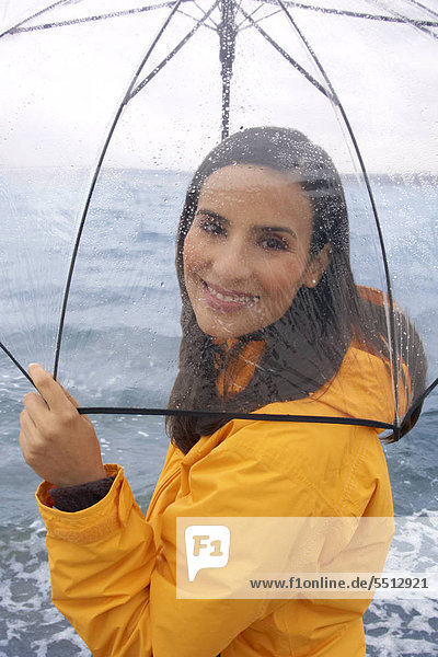 Junge Frau am Strand mit Regenschirm Junge Frau am Strand mit Regenschirm