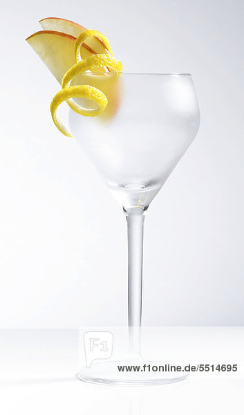 Leeres  gefrostetes Cocktailglas mit Deko aus Apfel und Zitronenschale