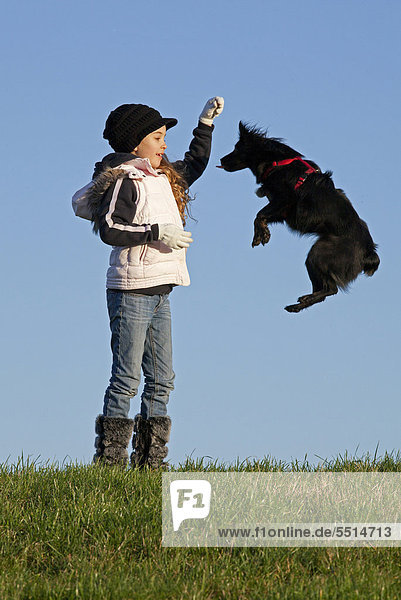 Mädchen lässt Hund springen