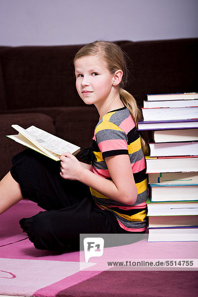 Girl  11  leaning against a stack of books