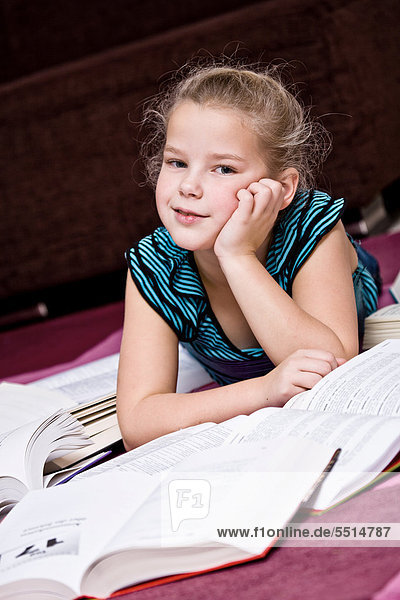 Girl  8  lying between books