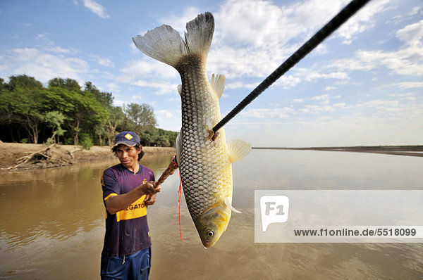 Young man from the indigenous Wichi Indians tribe fishing with a