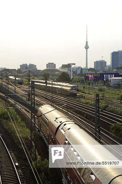 Train passing under the Warschau Bridge in Friedrichshain the television tower at back Berlin Germany Europe