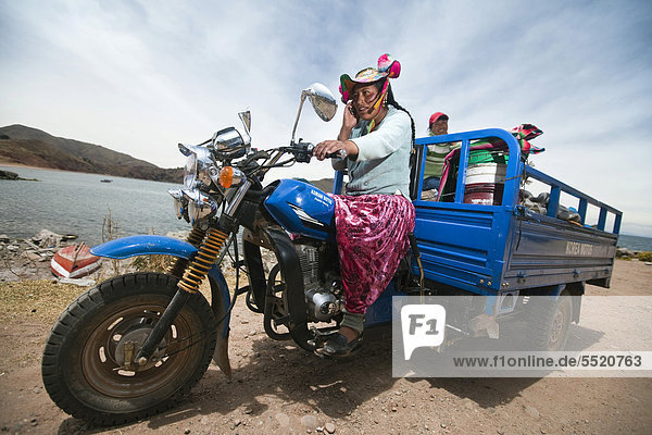 Mädchen  Angehörige der Quechua bringen auf ihrem umgebauten Motorrad den Fischfang zum Markt  Playa Chifron am Nordufer des Titicaca-Sees  Capachica  Peru  Südamerika