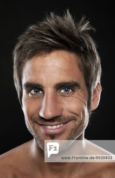 Junger  attraktiver Mann lächelt freundlich  Portrait