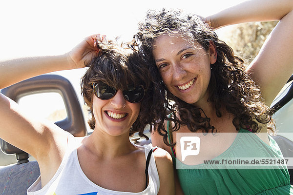 Frauen lächeln zusammen im Cabriolet