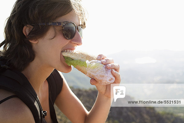 Frau isst Sandwich im Freien
