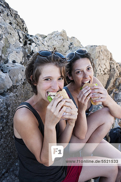 Wanderer essen Sandwiches auf Felsen