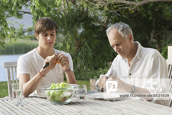 Father and son making salad outdoors