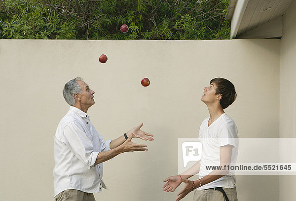 Vater lehrt den Sohn  im Freien zu jonglieren.