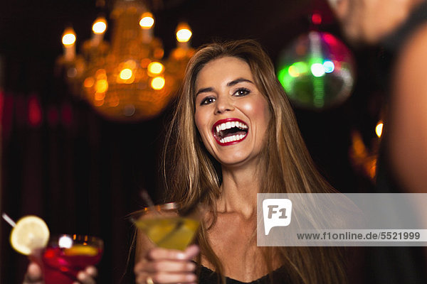 Smiling couple having cocktails in club