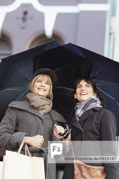 Women under umbrellas on city street