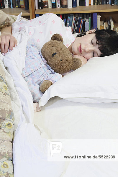Woman hugging teddy bear in bed