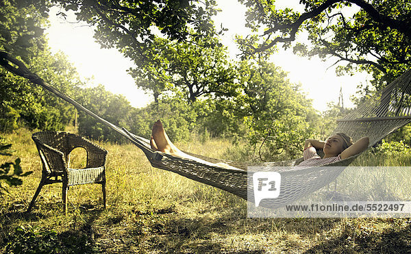 Mann entspannt sich in der Hängematte im Freien