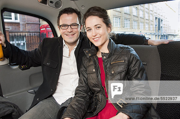 Couple smiling in back seat of car