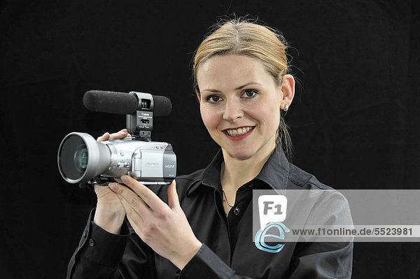 Young professional videographer shooting with a film camera