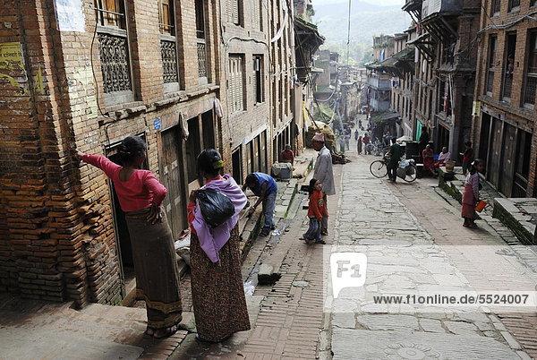 Nepalese people in traditional dress on historic street  Bhaktapur  Kathmandu Valley  Nepal  Asia