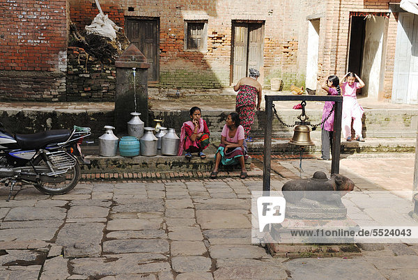 Frauen holen Wasser an einem Brunnen  Bhaktapur  Kathmandu Tal  Nepal  Asien