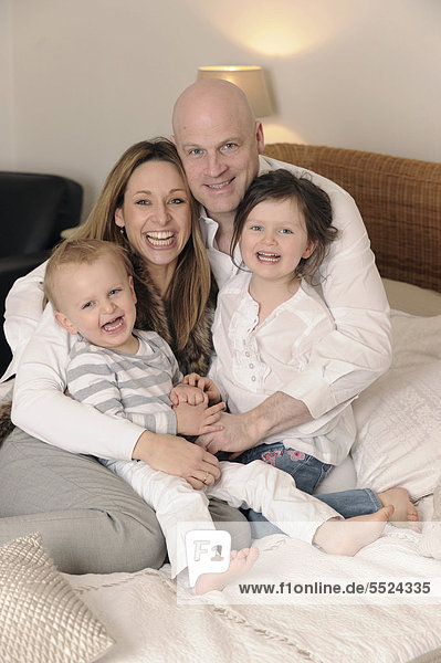 Family with two children on a double bed