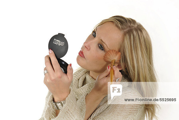 Young woman applying make-up  powder  brush