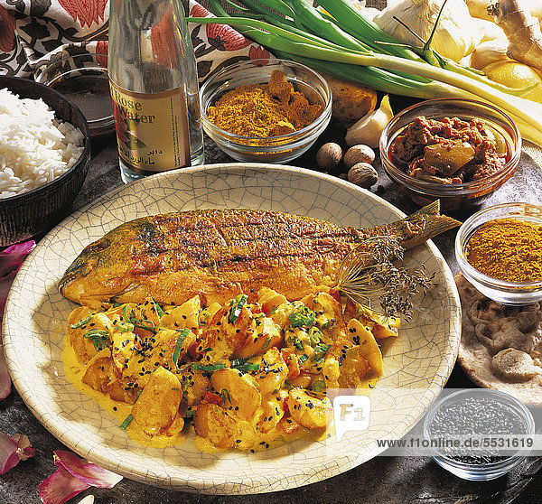 Curry-Kartoffeln  Bratkartoffeln fernöstlich gewürzt  mit feiner Joghurtsauce und schwarzem Sesam  Chili und Tomaten  Indien  Rezept gegen Gebühr erhältlich