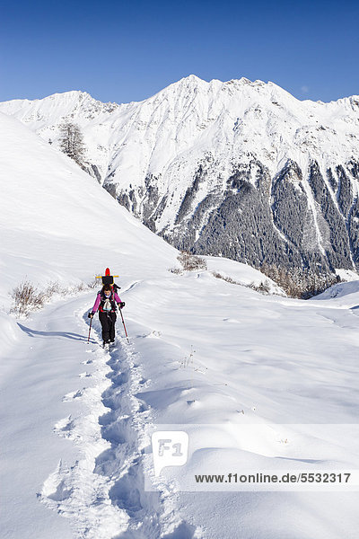 Hiker with snowshoes ascending to Jagelealm alpine pasture in Ridnauntal Valley above Entholz  looking towards Telfer Weissen Mountain  Alto Adige  Italy  Europe