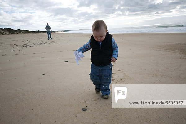 Kleinkind beim Spaziergang am Strand