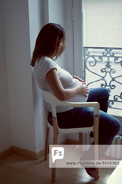 Schwangere Frau streichelt den Bauch  Seitenansicht