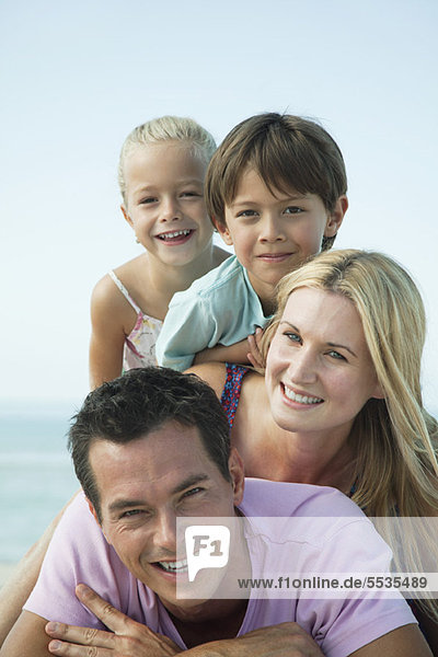 Family posing together at the beach  portrait