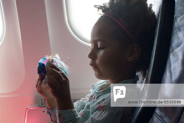 Little girl playing with toys on airplane