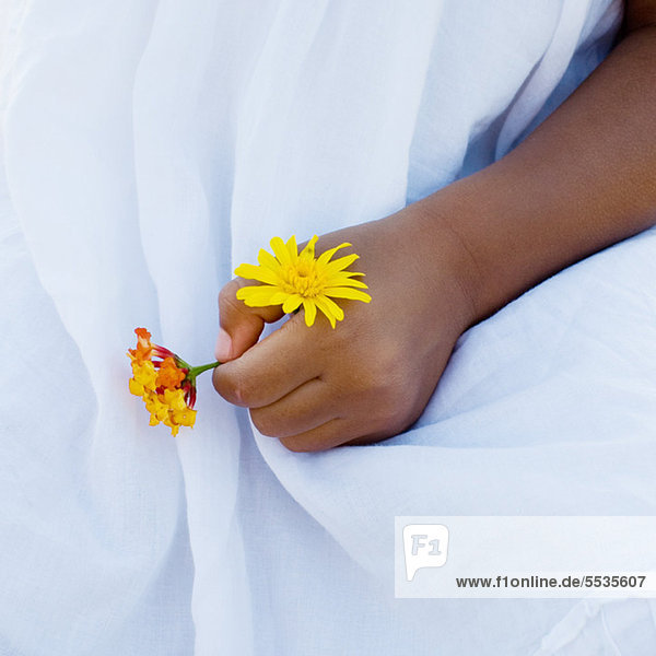 Child's hand holding flowers