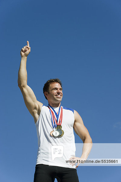 Männlicher Athlet mit erhobener Hand im Sieg