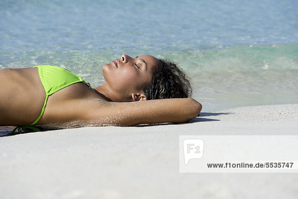 Young woman sunbathing on beach