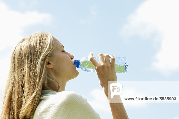 Frau trinkt Wasser in Flaschen