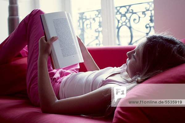 Mädchen-Lesebuch auf der Couch