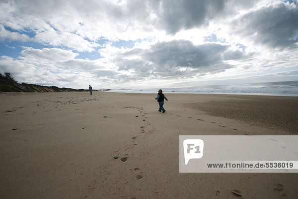 Kleinkind beim Spaziergang am Strand