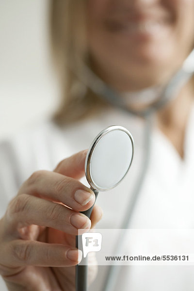 Doctor holding out stethoscope  cropped