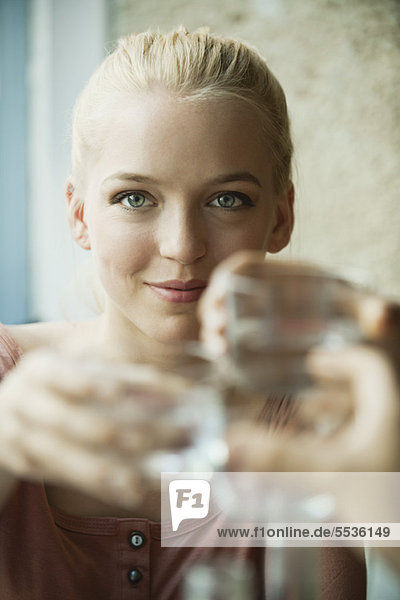 Young blond woman raising glass