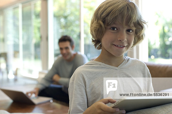 Junge mit digitalem Tablett im Wohnzimmer