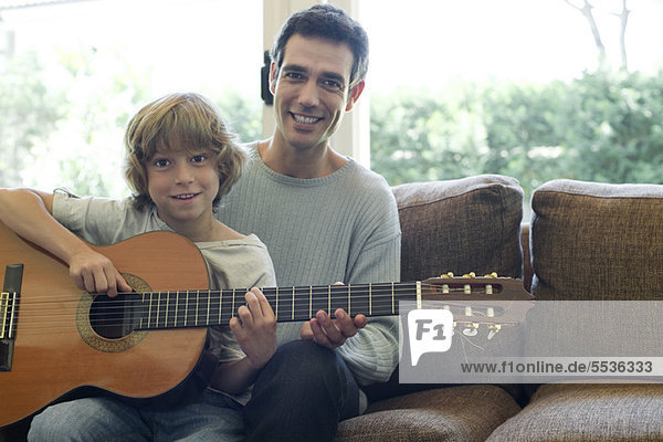 Vater lehrt Sohn Gitarre spielen