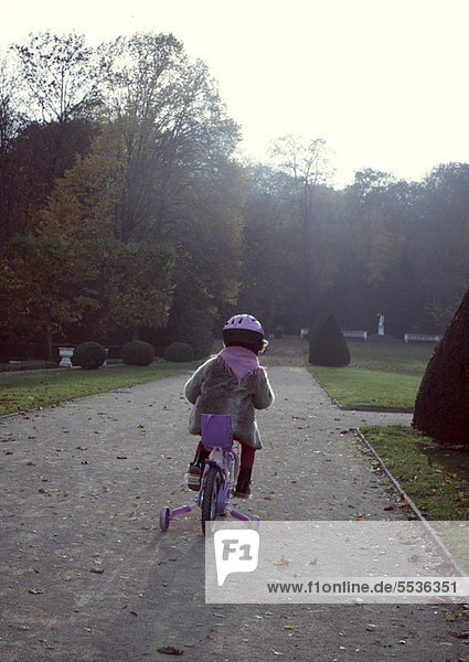 Kleines Mädchen auf dem Fahrrad  Rückansicht