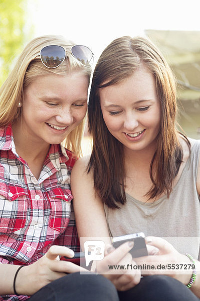 Two girls using cell phones