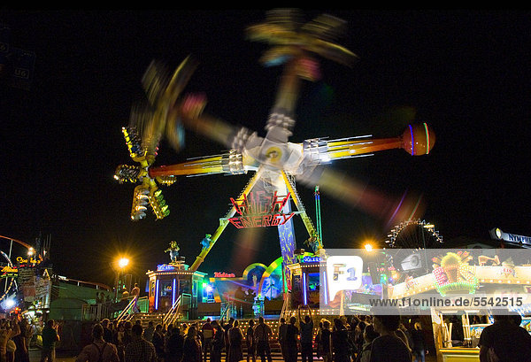 Oktoberfest  Wiesn  amusement rides  giant rotating pendulum at night  different rotational positions  Munich  Bavaria  Germany  Europe