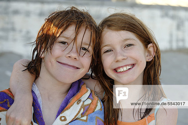Brother and sister with wet hair after swimming  smiling