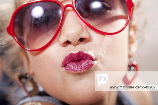 Teenager  Mädchen mit roter Sonnenbrille und Lippenstift