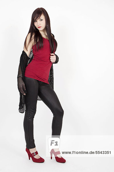 Young woman wearing a red top  latex leggings and red high heels