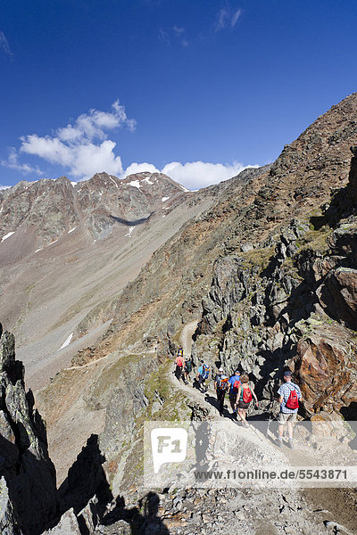 Hikers descending from Similaun Hut in the Schnalstal Valley through the Tisental Valley  Finailspitze Mountain at the rear  Alto Adige  Italy  Europe