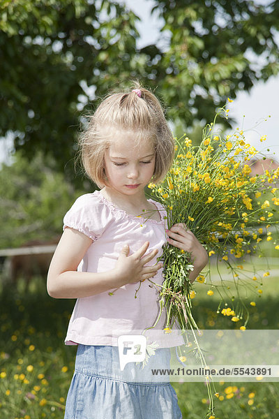 Mädchen mit Blumenstrauß auf einer Wiese
